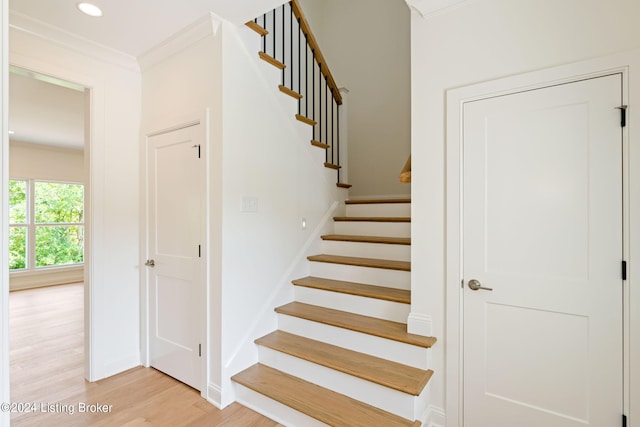 stairway featuring crown molding and wood-type flooring