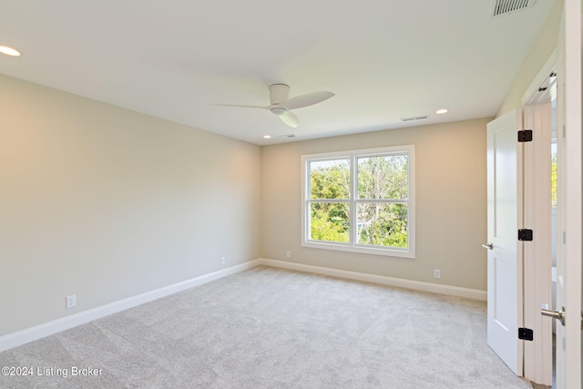 spare room featuring ceiling fan and light carpet