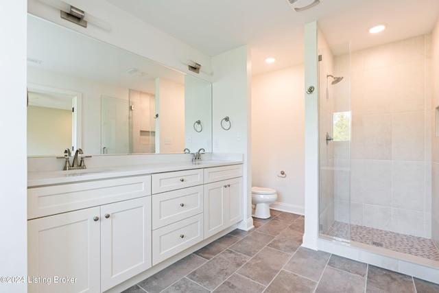 bathroom featuring tile patterned floors, tiled shower, toilet, and vanity