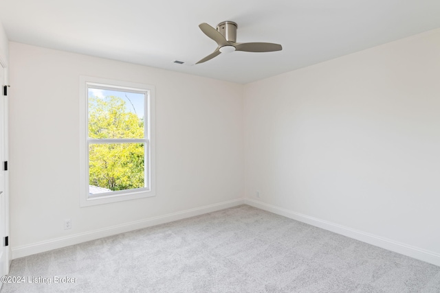 spare room with ceiling fan and light carpet