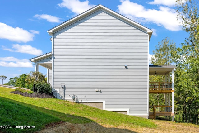 view of side of home with a balcony and a lawn