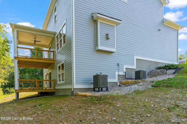 view of property exterior featuring a yard, a deck, ceiling fan, and central air condition unit