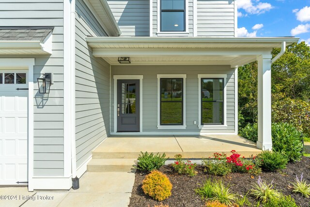 doorway to property featuring a garage and covered porch