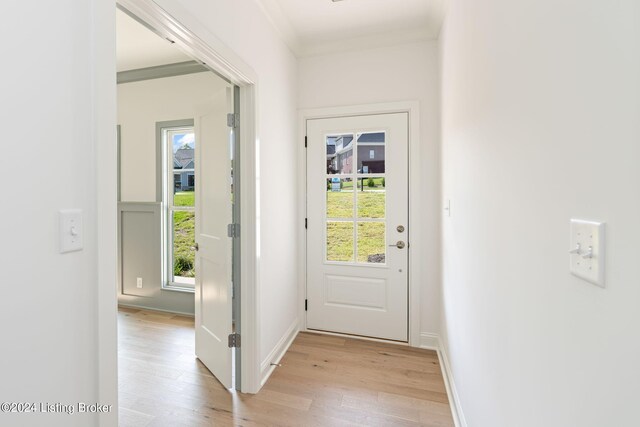 doorway featuring plenty of natural light, light hardwood / wood-style floors, and crown molding