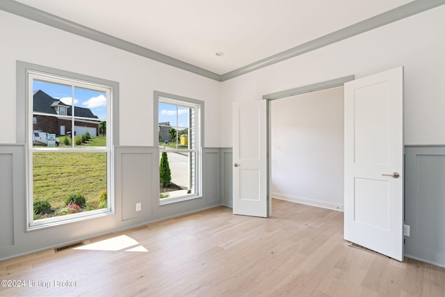 unfurnished room featuring crown molding and light hardwood / wood-style floors