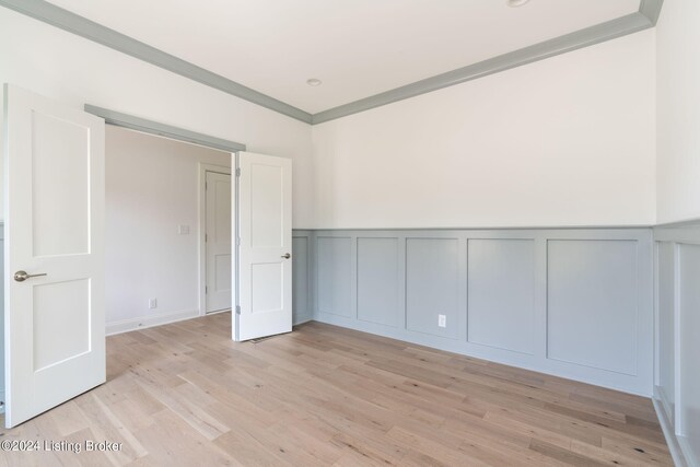 unfurnished room featuring ornamental molding and light hardwood / wood-style floors