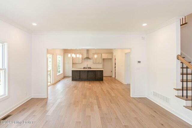 unfurnished living room featuring ornamental molding, light hardwood / wood-style flooring, and sink