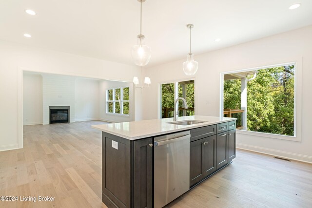 kitchen featuring light hardwood / wood-style flooring, a large fireplace, sink, and stainless steel dishwasher