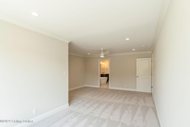 empty room featuring crown molding, light carpet, and ceiling fan