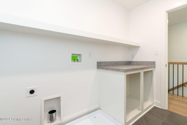 clothes washing area featuring dark tile patterned flooring, hookup for a washing machine, and electric dryer hookup