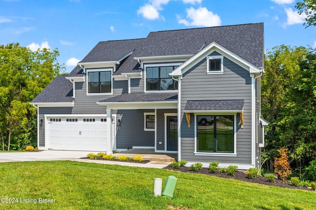 view of front of house with covered porch, a front yard, and a garage