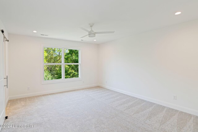 unfurnished room featuring ceiling fan and light colored carpet