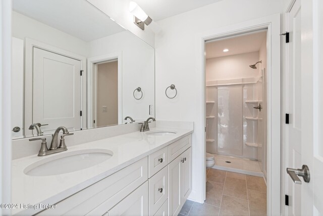 bathroom with tile patterned floors, walk in shower, toilet, and vanity