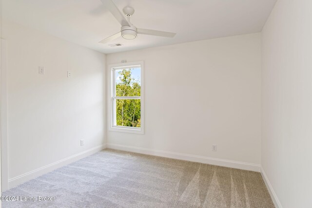 carpeted spare room with ceiling fan