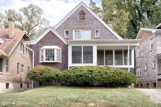 view of front of property with a front lawn and a sunroom