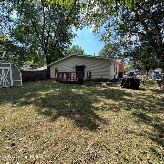 view of yard featuring a deck and a shed