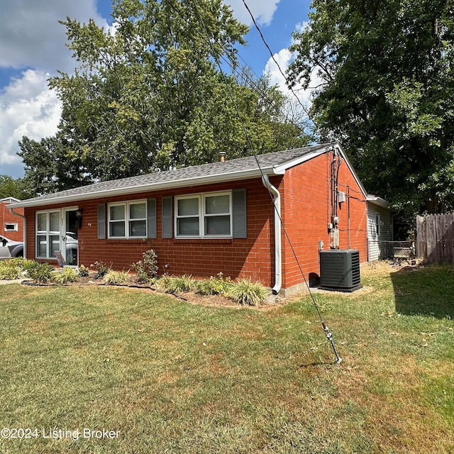 view of front of home featuring a front lawn and central AC