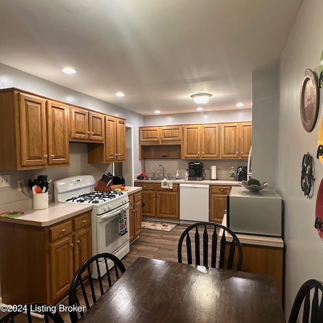 kitchen featuring white appliances, dark hardwood / wood-style floors, and sink