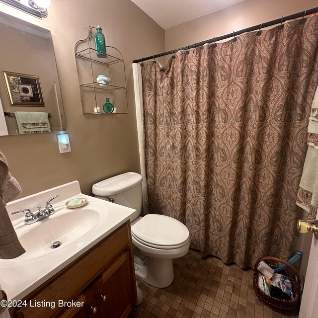 bathroom with vanity, toilet, walk in shower, and tile patterned floors