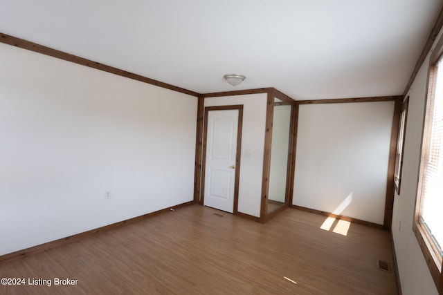 unfurnished bedroom with crown molding and wood-type flooring