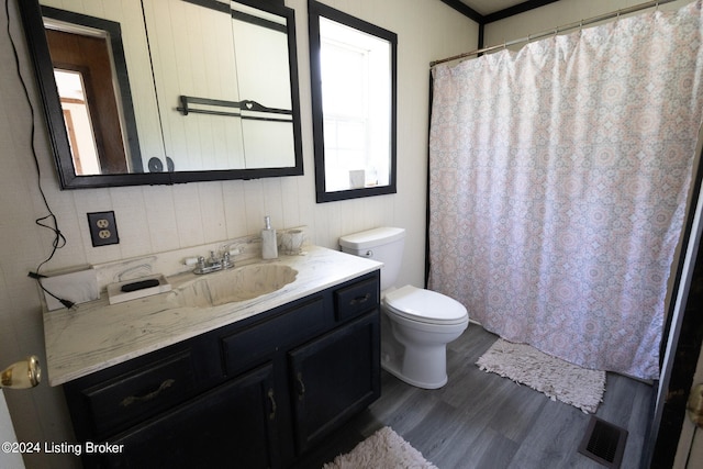 bathroom with vanity, toilet, and hardwood / wood-style floors