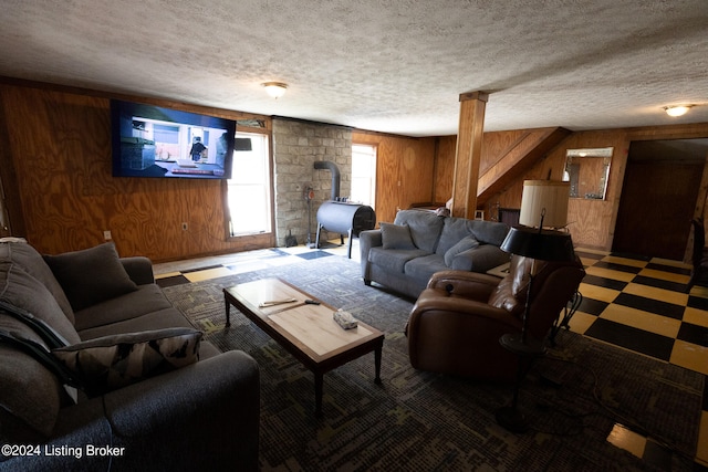 living room featuring wooden walls and a textured ceiling