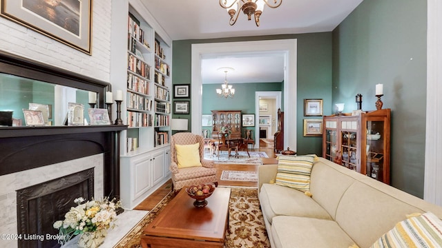 living room featuring a notable chandelier, built in features, and light hardwood / wood-style floors