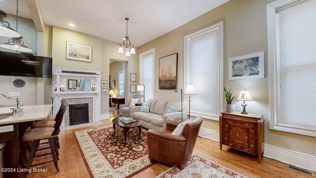 living room with light hardwood / wood-style flooring and a chandelier