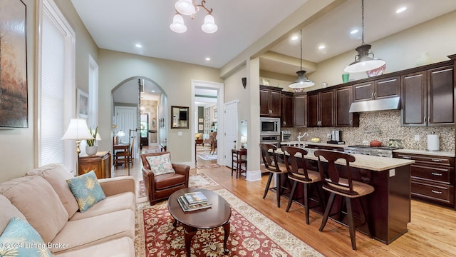 living room featuring a notable chandelier and light hardwood / wood-style flooring