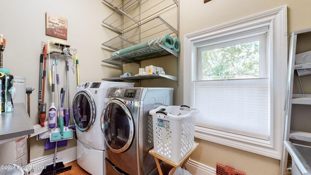 clothes washing area with washing machine and dryer and hardwood / wood-style flooring