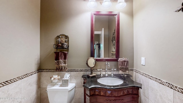 bathroom featuring tile walls, vanity, and toilet