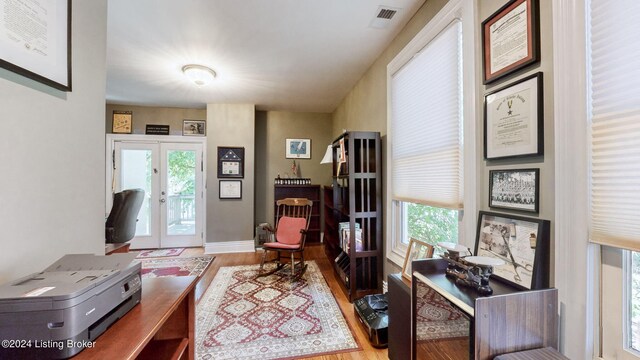 office featuring light wood-type flooring, french doors, and plenty of natural light