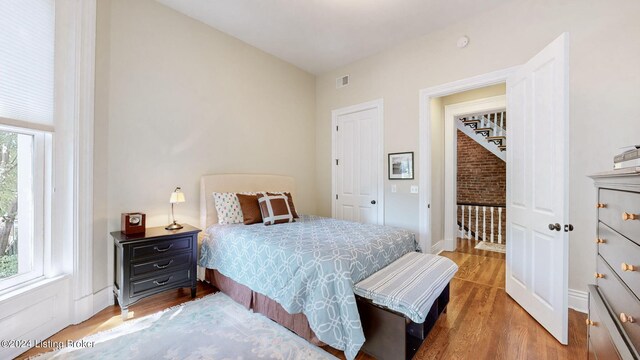 bedroom featuring hardwood / wood-style flooring and multiple windows