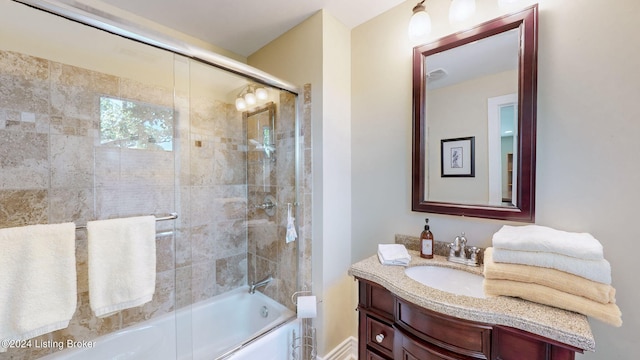 bathroom featuring shower / bath combination with glass door and vanity