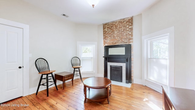 living area featuring light hardwood / wood-style floors and a large fireplace