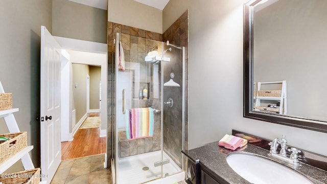 bathroom featuring hardwood / wood-style flooring, vanity, and a shower with shower door