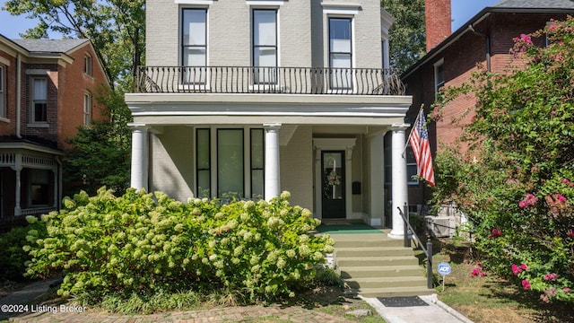 entrance to property featuring a balcony and covered porch