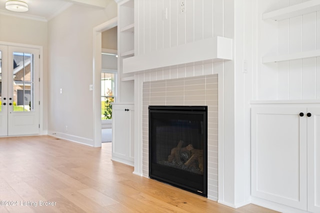 unfurnished living room with crown molding, french doors, and light wood-type flooring