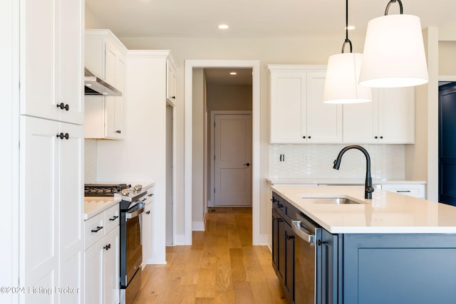 kitchen featuring hanging light fixtures, white cabinetry, light hardwood / wood-style flooring, range hood, and stainless steel appliances