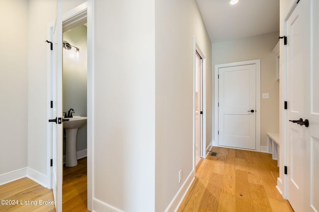 hall featuring sink and light hardwood / wood-style flooring