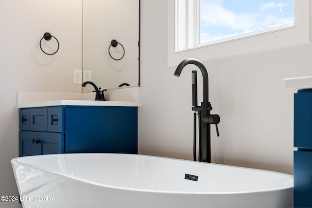 bathroom featuring vanity and a bath