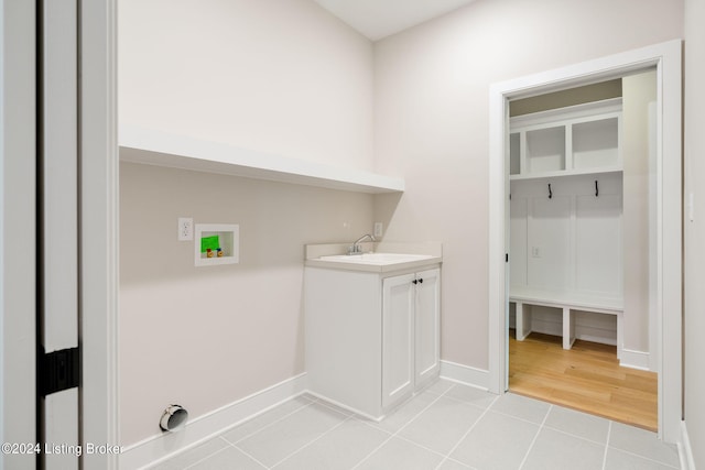 clothes washing area with hookup for an electric dryer, sink, washer hookup, and light wood-type flooring