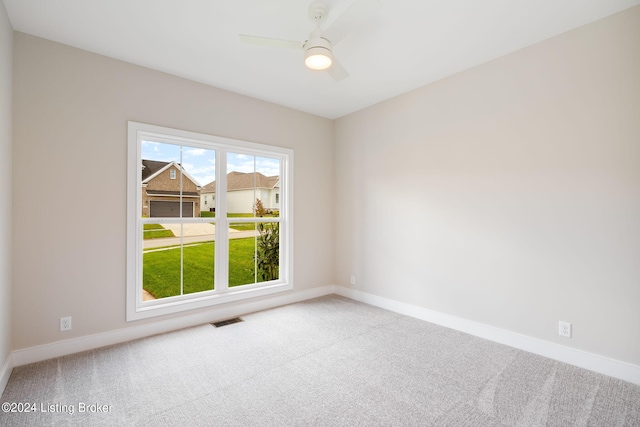 carpeted spare room featuring ceiling fan