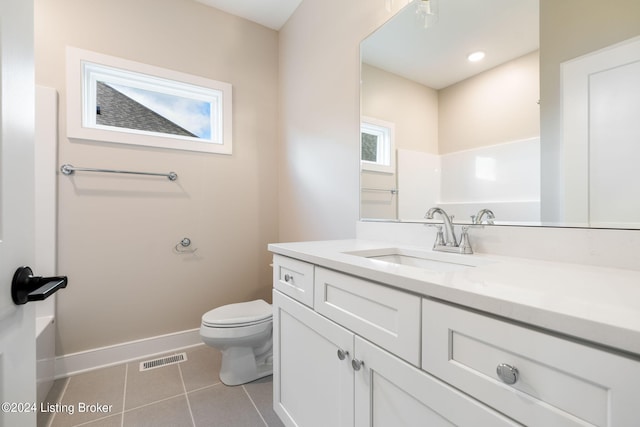 bathroom featuring a wealth of natural light, vanity, toilet, and tile patterned flooring