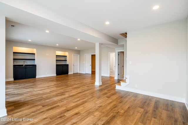 unfurnished living room with sink and hardwood / wood-style flooring