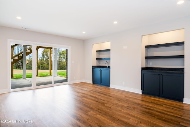 unfurnished living room with dark wood-type flooring and sink