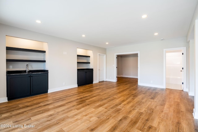 unfurnished living room featuring light hardwood / wood-style floors and sink