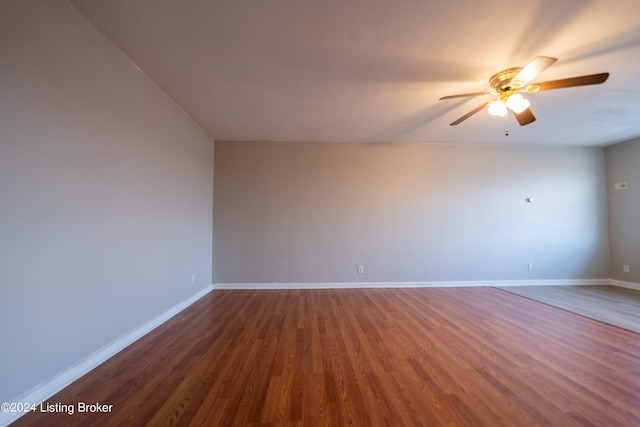 empty room featuring dark wood-type flooring and ceiling fan