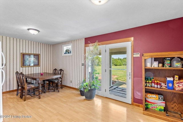 dining room featuring a textured ceiling and light wood-type flooring