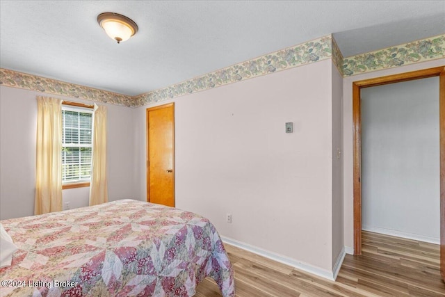 bedroom with hardwood / wood-style flooring and a textured ceiling